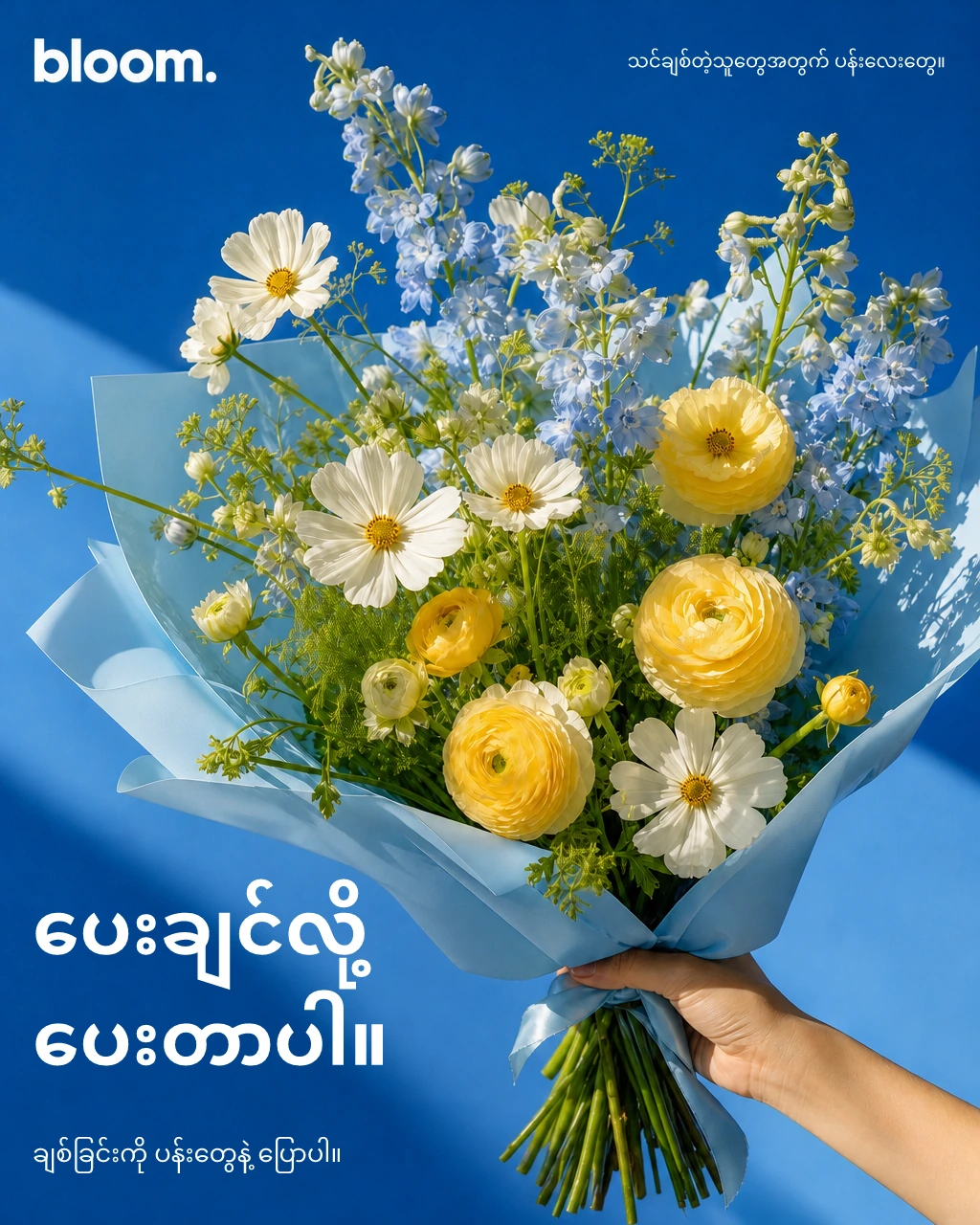 Bloom florist ad: a yellow and blue bouquet. Burmese copy: Just because. Say it with flowers.
